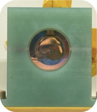 Thermal vapour cell assembly in its mount, viewed through a circular optical port